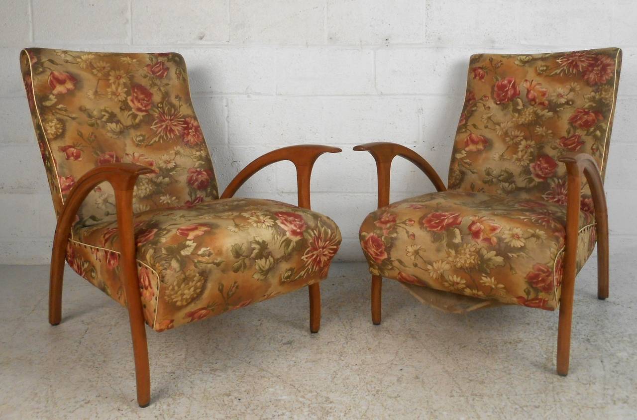 This unique pair of lounge chairs combine style and comfort, featuring wide slightly reclining seat backs, sculpted armrests, and are reupholstery-ready. Please confirm item location, (NY or NJ).