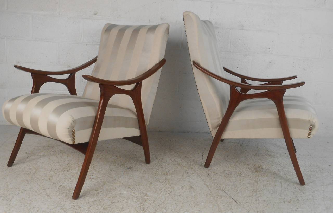 Sculptural walnut open-frame armchairs with Classic midcentury styling make a comfortable and elegant addition to any interior. Comfortable Mid-Century Modern design perfect for home and office. Please confirm item location (NY or NJ) with dealer.