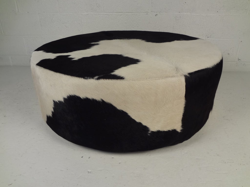 Large round cowhide covered ottoman/coffee table.