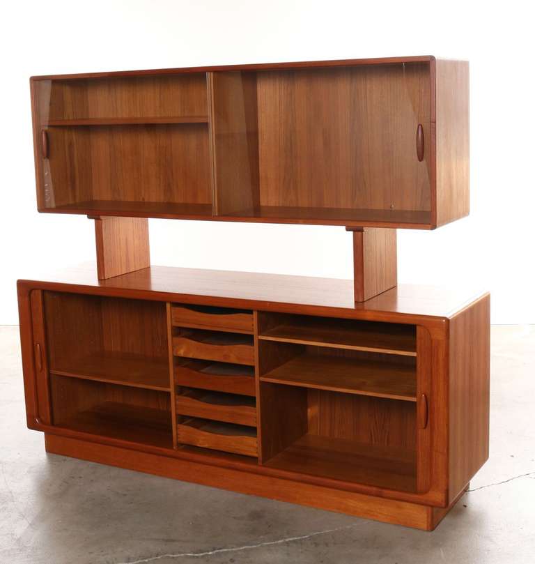 This generous sized teak sideboard and hutch combination has everything you would need for storage. Features two inside sections as well as center 5 drawers. The removable hutch has two glass doors that slide open and allow room to display glassware