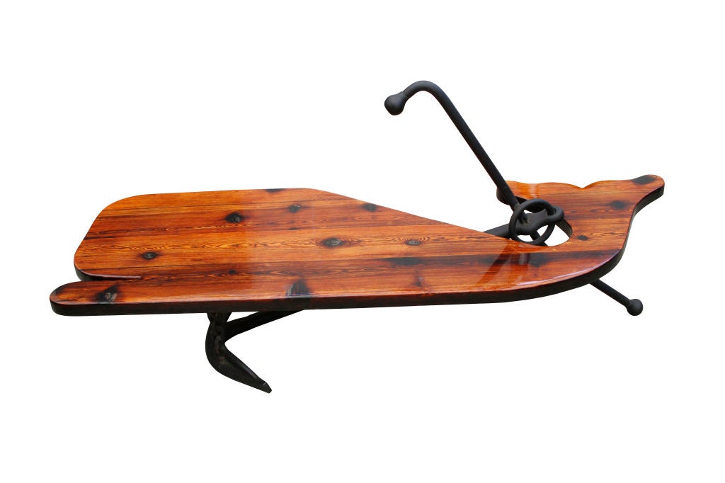 This coffee table and bench set is sure to bring the Marina indoors. Charming handmade table top is in the shape of a whale with a cast iron base crafted as a boat anchor. The table is heavily varnished for weather protection and is in wonderful
