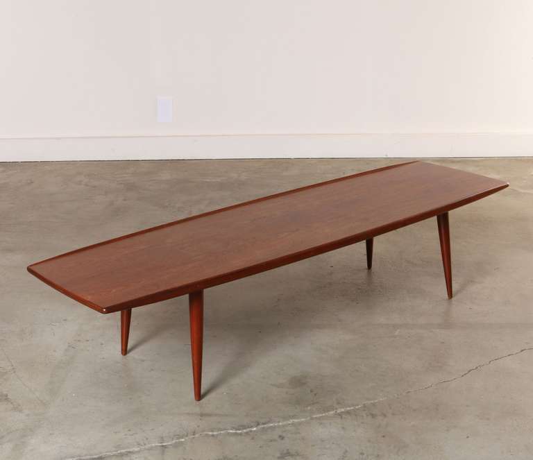 Sleek teak coffee table made by Moredo of Denmark circa 1960's
features a teak top with raised lip to edge, tapered sides and removable teak tapered dowel legs. Original finish and the underside is stamped 