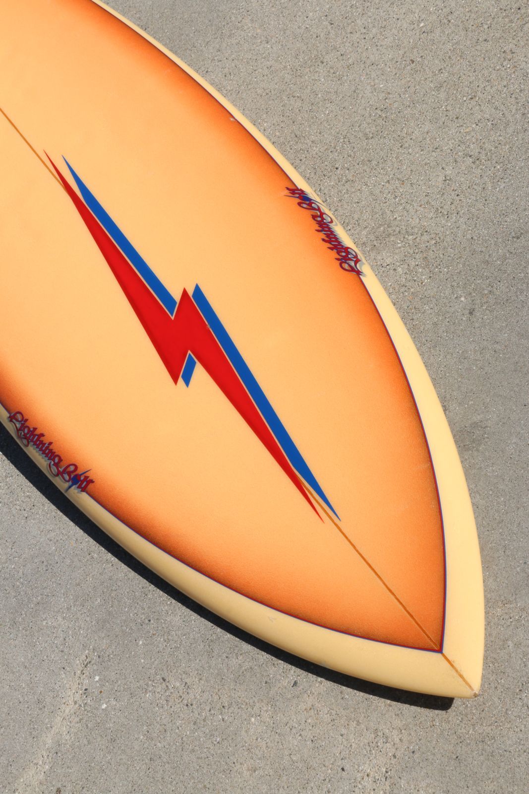 This is a rare and wonderful late 1970s airbrushed round pin Lightning Bolt surfboard with detachable single fin. Beautiful red and blue pin-striping with feathered airbrush that blends from dark to light and a prominent double lightning bolt that
