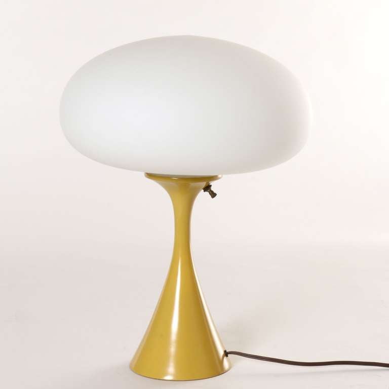 A classic 1960's mushroom table lamp with frosted glass globe and spun aluminum base in original powder coated mustard yellow finish, one of the most rare and desirable colors.
The original Laurel manufacturer's label is still intact on the