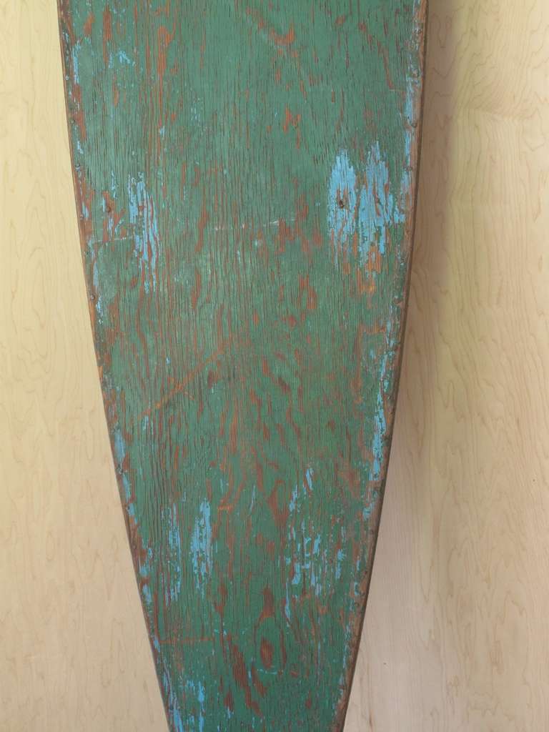 Character and class, this vintage green paddle board was probably built in the 1930s. The number 10 painted on it implies that it was used as a rental board back when paddle boards were the rage and rented to beach goers so that they didn't have to