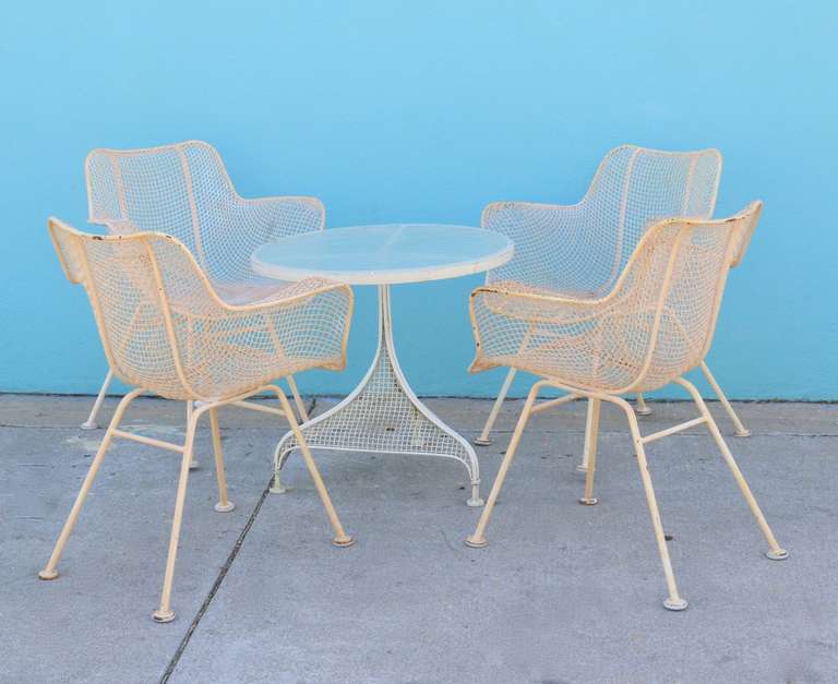 Table and 4 chair set by Russell Woodard, created for his 1950's Sculptura collection. Noted for it's classic iron woven mesh and ergonomic shape Woodard made his mark on the furniture industry with this design, presenting an innovative take on