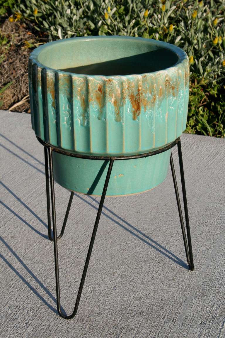 Beautiful artisan ceramic planter in sea foam green and gold drip glaze.
Comes with original black mid century wire iron planter stand.

The Robinson Ransbottom Pottery Company was established in 1900 in Roseville, Ohio at the time they were the