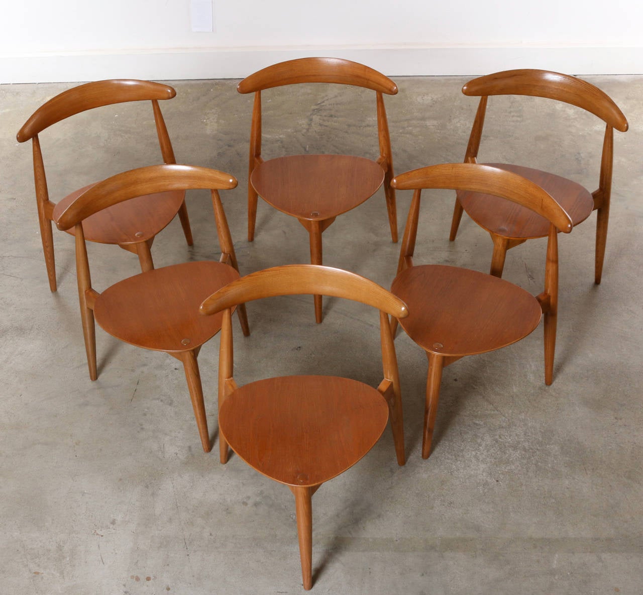 Rare, wonderful and in excellent condition. This fully refinished vintage chair set by Hans Wegner is one of the icons of Scandinavian Modern Design. The three-legged, tripod chair No. 4103 is commonly referred to as the “Heart Chair” on account of