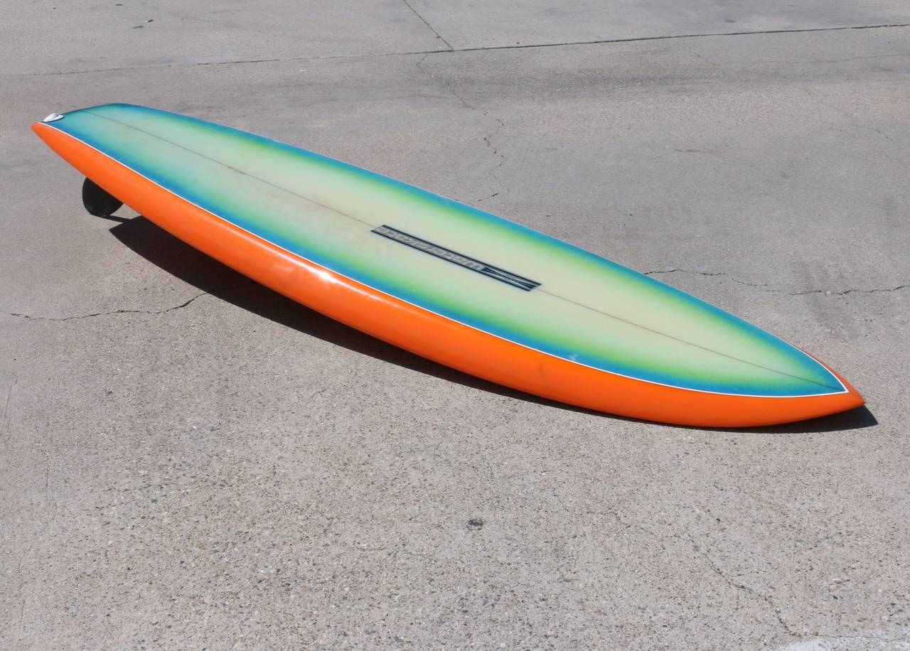 This board explodes with eye-catching color and verve. We love the expertly airbrushed deck in colors of summer: orange, bright sky blue, spring green and light-lime off-set by a white pin-stripe and accented with saturated orange rails and bottom. 