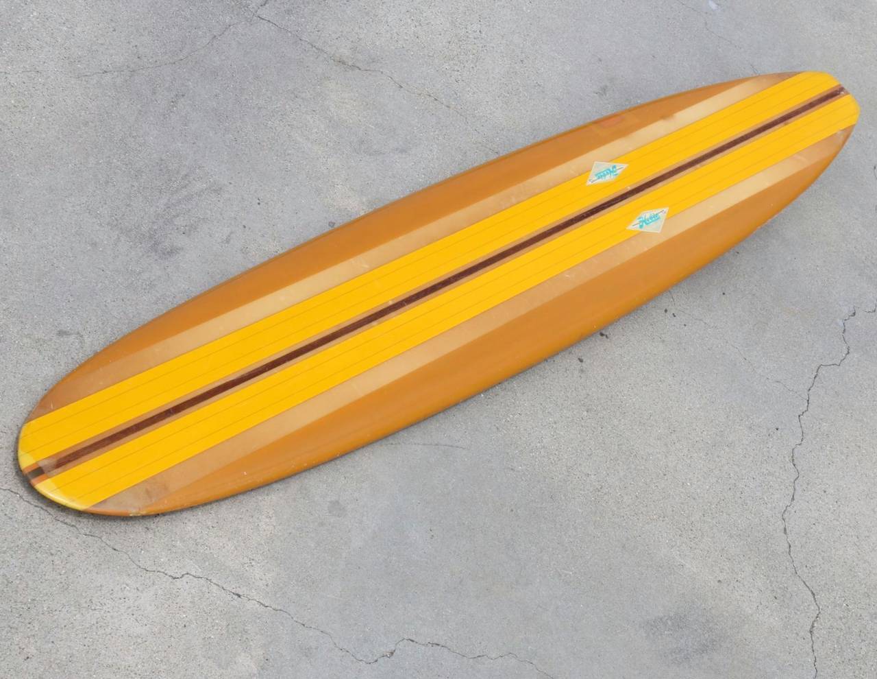 This classic longboard from the days of Beach Boys music and 1960s long boarding warms our heart.  Just looking at it conjures up dreams of California's golden surf years. At 9 feet, 11 inches long and a thick redwood stringer running down it's