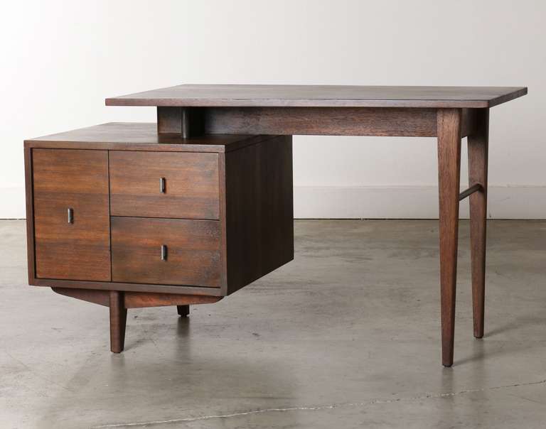 Architectural styling and mid century lines give this desk a graphic silhouette that makes it an eye-catcher from all directions.   Made of mahogany this desk was designed by John Keal for the Brown Saltman Furniture Company in California circa