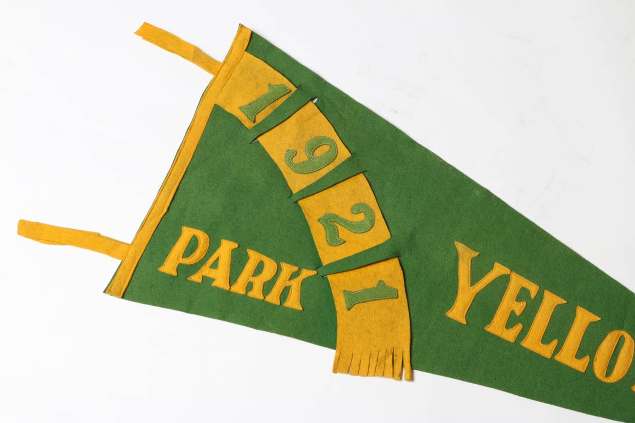 Almost 100 years old, this Yellowstone Park felt pennant is a rare and wonderful decorative item. Fresh green, golden yellow and appliqué design flair signals the celebratory days of the 1920s with eye-catching spectacle.  A wonderful popular