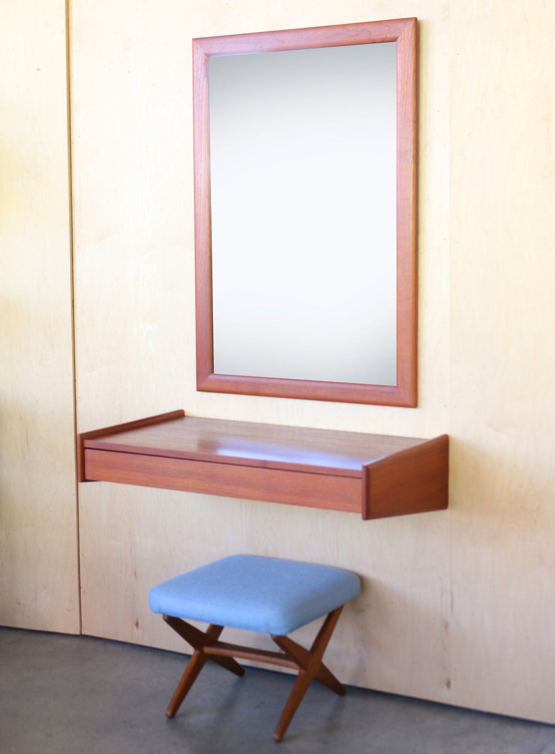 This three-piece vanity set consists of mirror, drawer unit and adjustable stool.  It's wonderfully unique because it mounts easily to a wall. It is in very good original condition demonstrating only minimal wear. The stool adjusts to two heights by