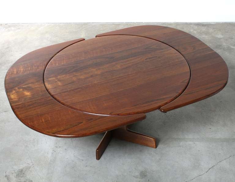 Prized equally as a work of art and as a dining table this masterpiece by Gerald McCabe is a one of a kind creation that has stood the test of time.  The table top and leaves, cut from a solid piece of African shedua wood, create a unique,