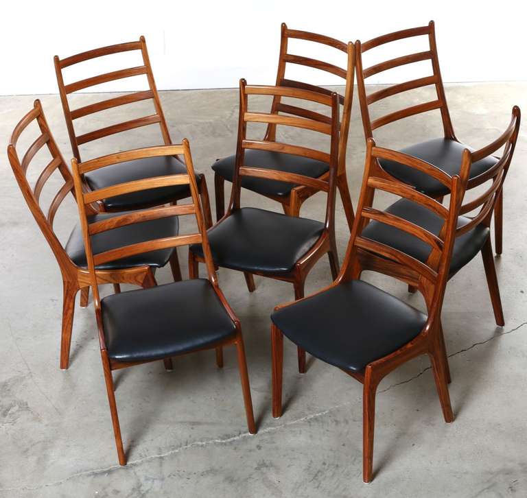 8 beautiful rosewood and leather Scandinavian modern dining chairs designed by Kai Kristiansen for the Danish Korup Stolefabrik Furniture Company.

These are extremely comfortable dining chairs, they feature an angled high back that cradles the