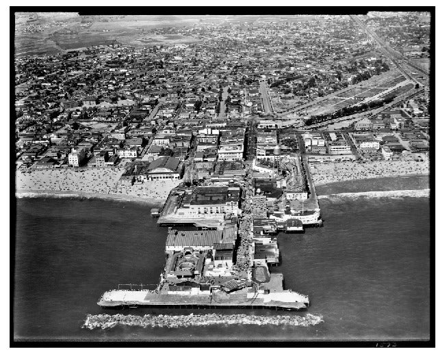 This is a contemporary archival photographic print from a 10 x 12 negative, printed on archival paper resembling the old silver gelatin paper of the time. This image was taken in the 1930s and features an aerial view of the Venice Beach pier.