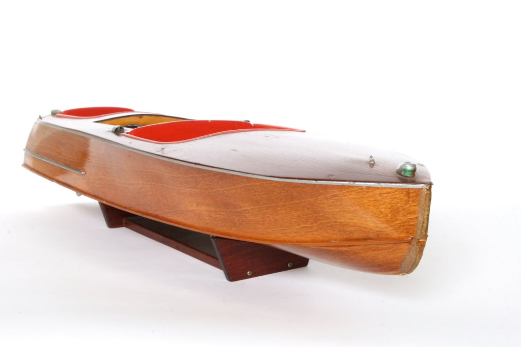 Probably a Chris Craft, this model was probably a kit that required painstaking construction.  The boat is missing a few pieces but displays beautifully.  Mahogany deck with metal trim and red interior.  We feel that the battery powered remote