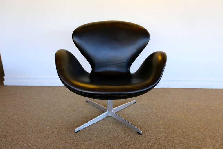 Early Arne Jacobsen Swan Chair for Fritz Hansen.  This piece is in lightly distressed black leather.