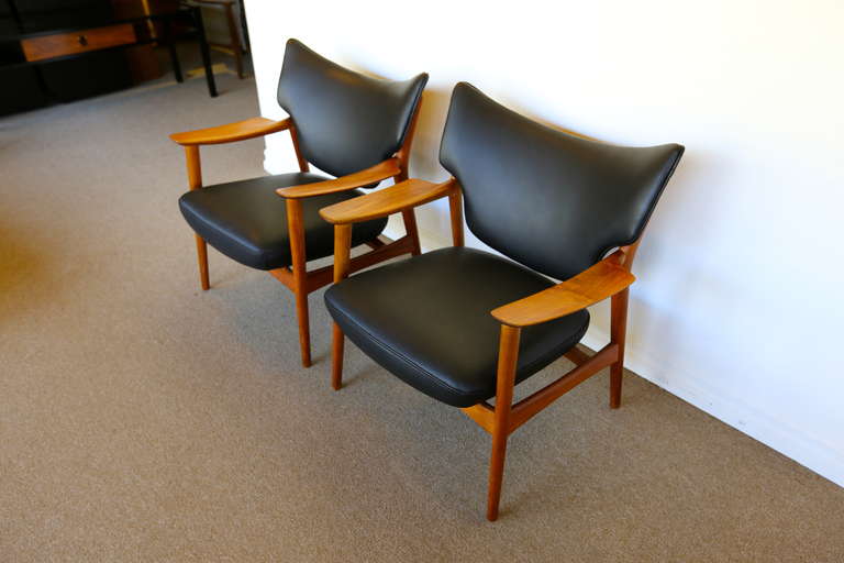 Pair of sculptural leather and teak lounges by Peter Wessel.