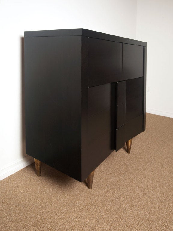 VANLEIGH New York ebonized mahogany, leather and brass chest / tall dresser.  Leather wrapped pulls on brass legs.  Sculptural in design.  Vanleigh furniture showroom represented some of the finest designers of the period.