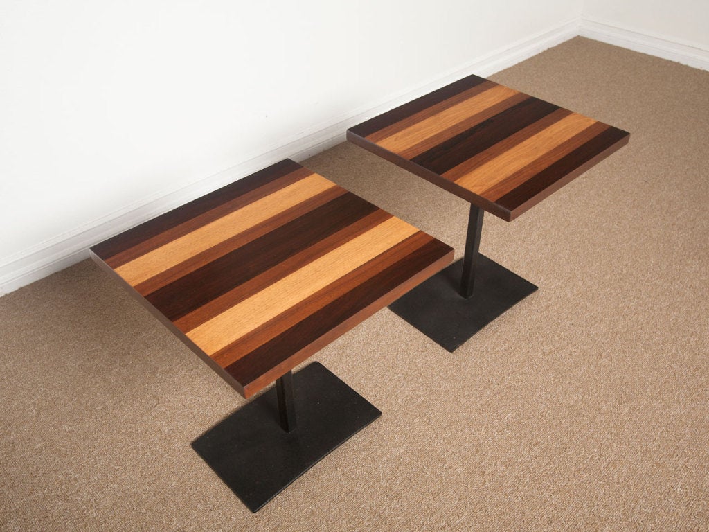 Pair of side tables by Milo Baughman for Directional. Mixed wood top consisting of strips of rosewood, ash and walnut on a heavy black iron base.