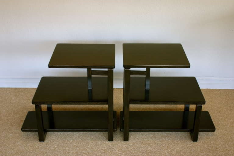Pair of ebonized three tiered side tables.