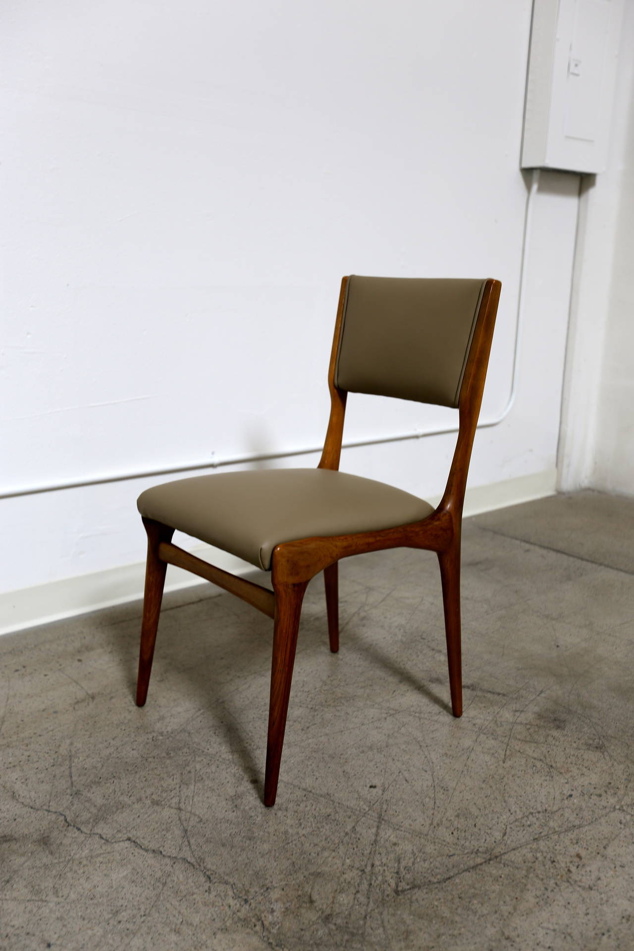 Set of six sculptural Italian dining chairs by Carlo de Carli, circa 1950s. The frames are in original condition with only minor wear. The beige leather is new and in excellent condition.