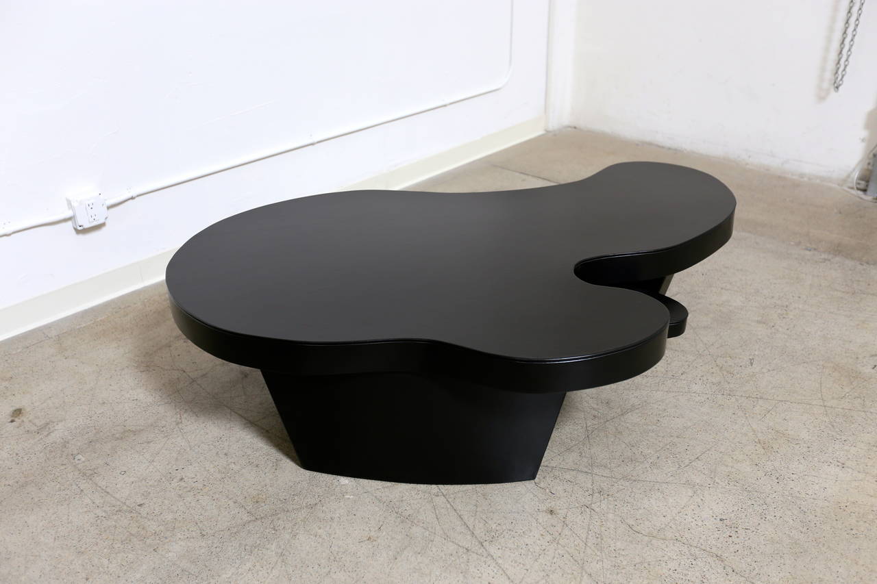 Large leather wrapped biomorphic coffee table. This piece is wrapped in real black leather.