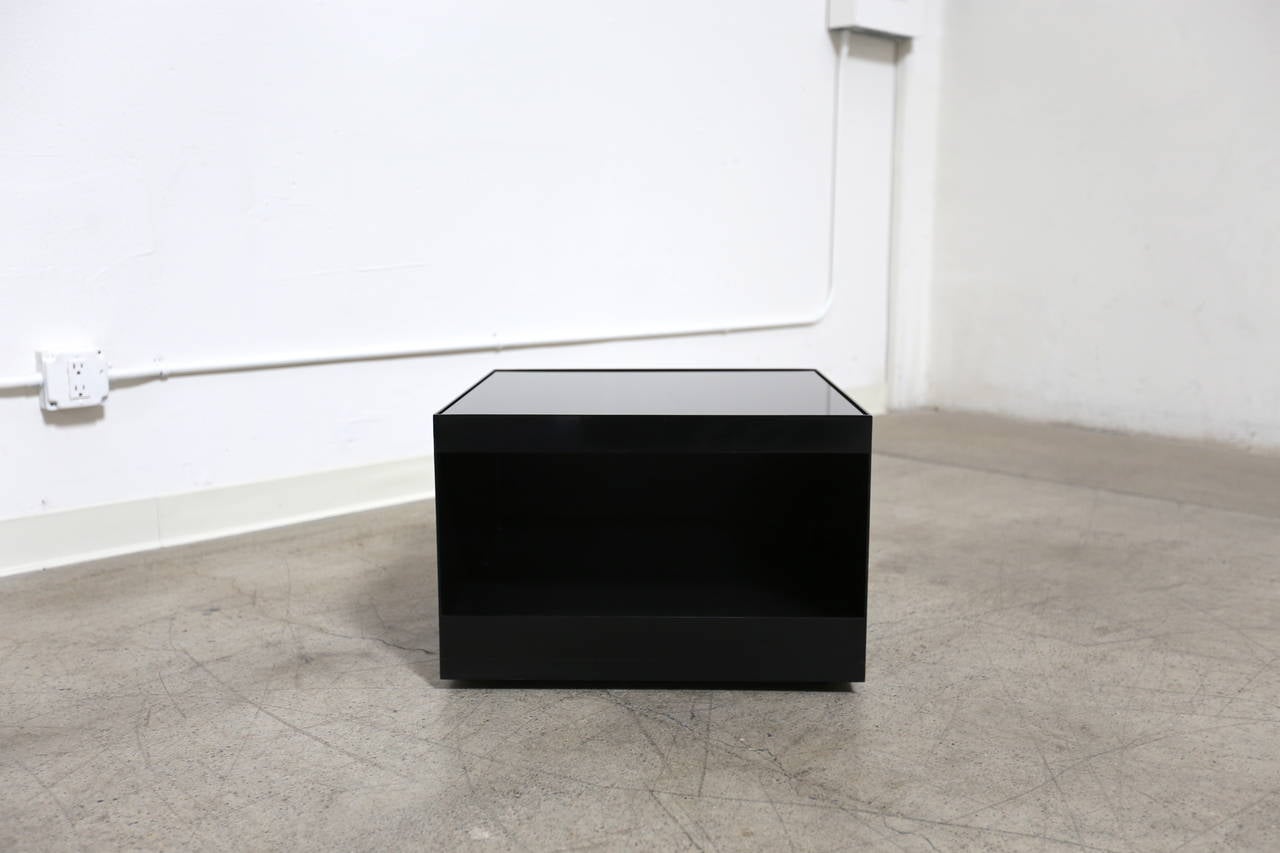 Black Enameled and Smoked Glass Joe D'urso Side Table.  This piece has hidden castors and rolls with ease.