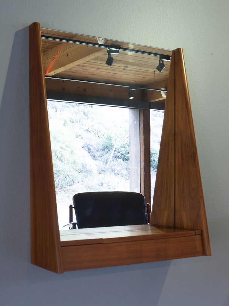 Walnut wall mirror by PETER PEPPER PRODUCTS.  This piece has a small storage area and would be perfect in a entry way. 