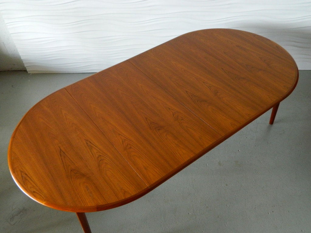 This Svend Madsen teak dining table has a beautiful wood grain and oval legs. Table measures 48