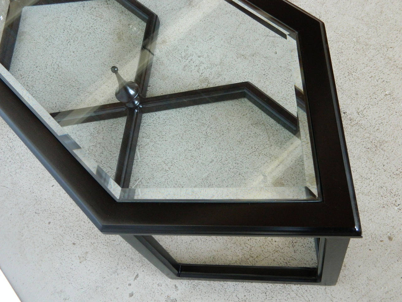This Hollywood Regency style coffee table has a striking black painted finish and bevelled glass top.