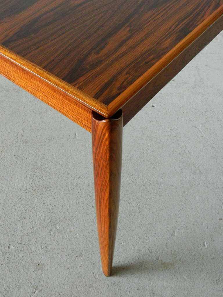 Gorgeous mid century modern rosewood table with active grain. Table comes with one leaf which measures 23