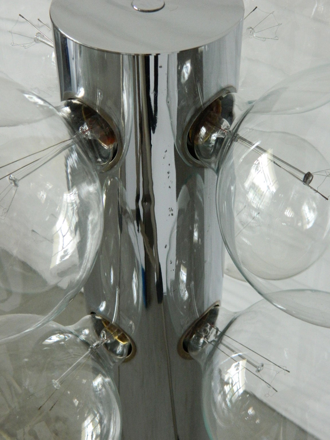 Eight globe bulbs illuminate from a simple chrome cylinder in this TSAO Designs floor lamp.