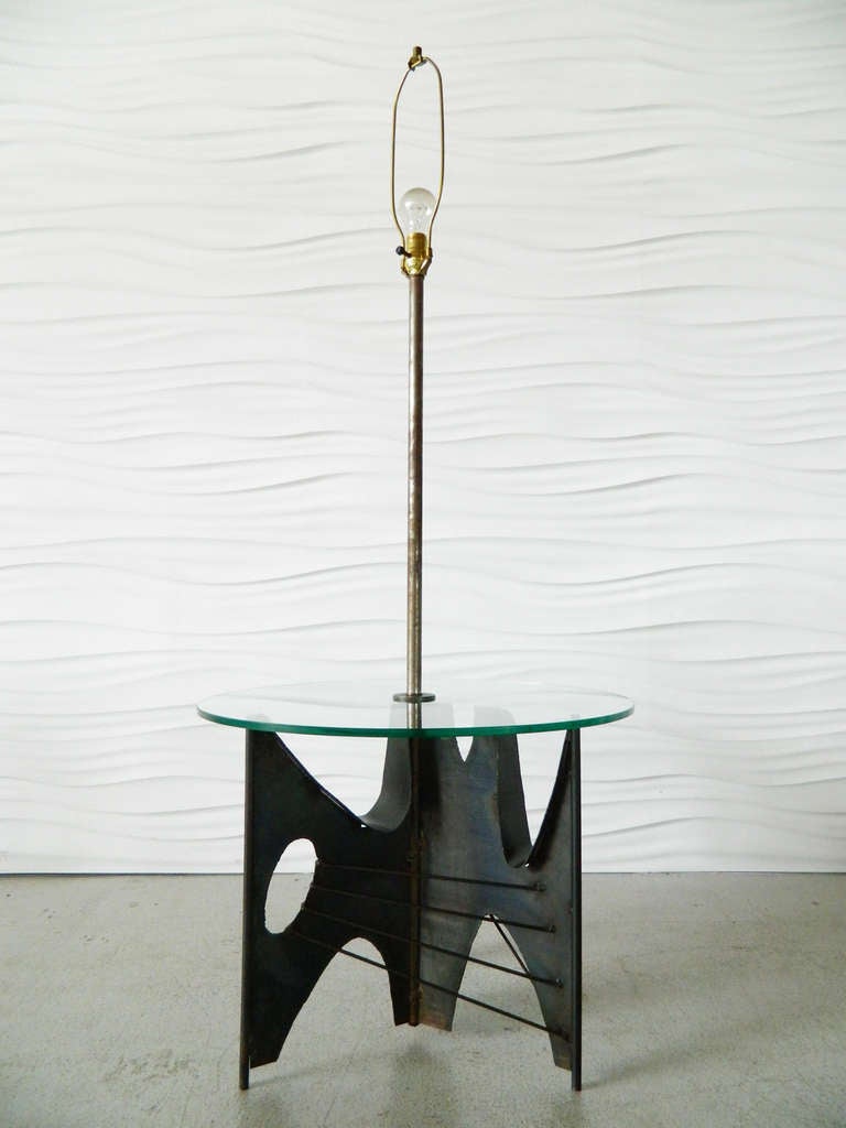 In the style of Harry Balmer, this brutalist metal sculpture serves as a base for both a floor lamp and glass top table.