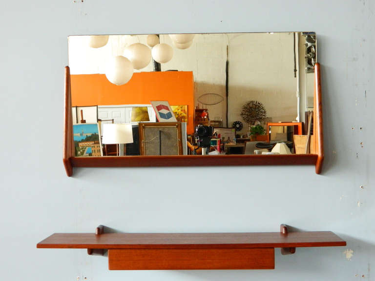 This handsome teak two-piece mirror and floating shelf is attributed to Aksel Kjersgaard. Made in the 1960s. The floating shelf has a single drawer.

MIrror: 32.25