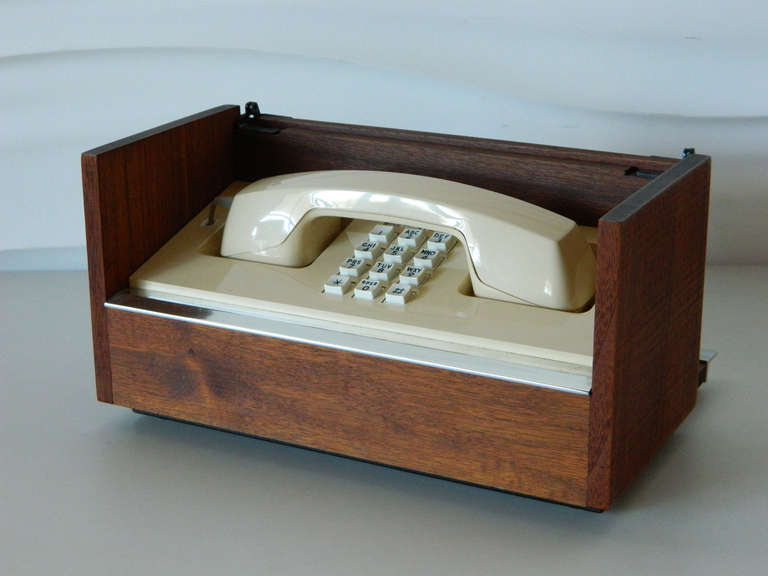 Concealed in a handsome walnut case, this Western Electric telephone has a retractable cord and push-button dialing. Original condition, fully functioning with a distinctive vintage ring.