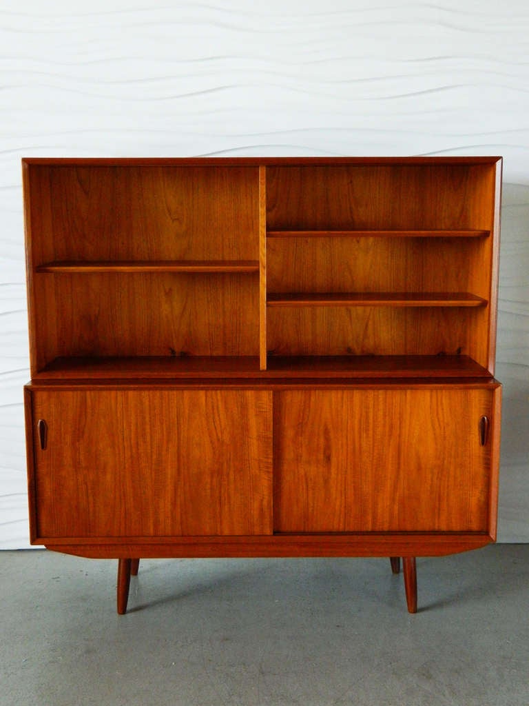 This mid-century Danish modern teak sideboard has sliding doors which conceal four felt-lined drawers and open shelving.  The removable hutch measures 59