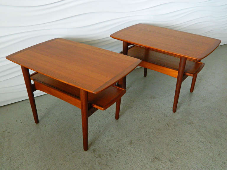 This pair of Danish Modern teak end tables by Bramin Mobler has movable lower shelves which can be pulled out and used as serving trays. 
Trays measure 24.5