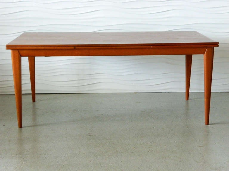 Generously-sized Danish modern teak dining table by JL Moller. The table has two built-in 22.75
