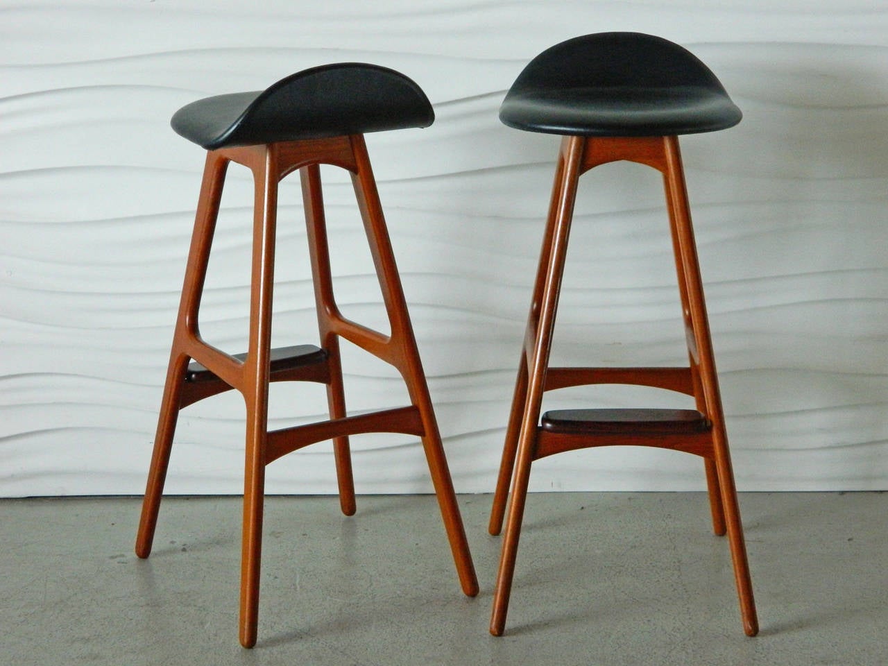This gorgeous pair of Eric Buck teak stools has rosewood foot rests and black vinyl seats. Made in Denmark.