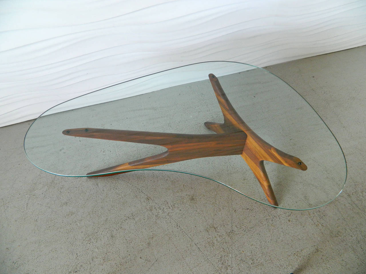 This iconic design by American Adrain Pearsall has an oiled walnut base and biomorphic-shaped glass top.