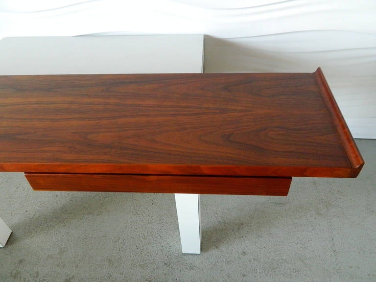 This mid-century modern floating shelf/console is in the style of Founders Furniture. It is made of walnut and has one single drawer.