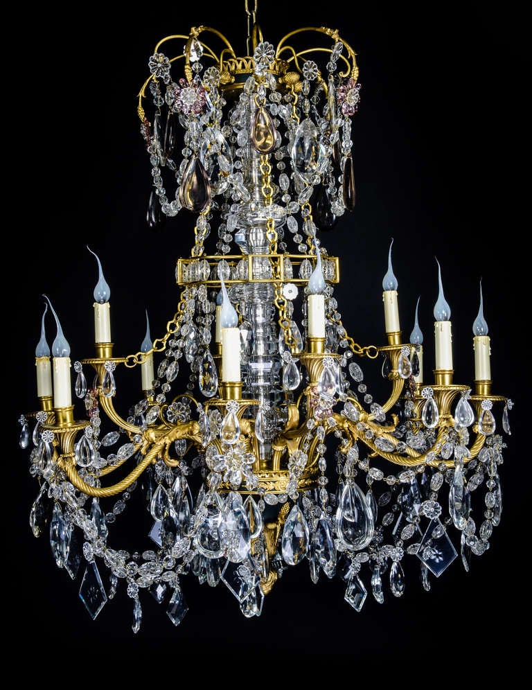 A magnificent Antique French Louis Gilt bronze, patinated bronze & cut crystal multi light double tier chandelier of exquisite workmanship embellished with fine cut crystal prisms, chains & further adorned with unique cut crystal flowers by