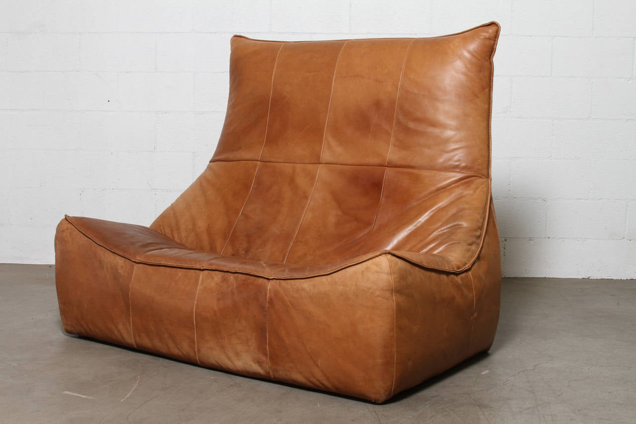 Two-Seater Natural Leather Sofa and Ottoman designed by Gerard van den Berg for Montis 1970. Beautiful Patina and Amazing Piece of Furniture Design! Gerard Van Den Berg arguably defined a turning point from classic Mid-Century Dutch furniture design