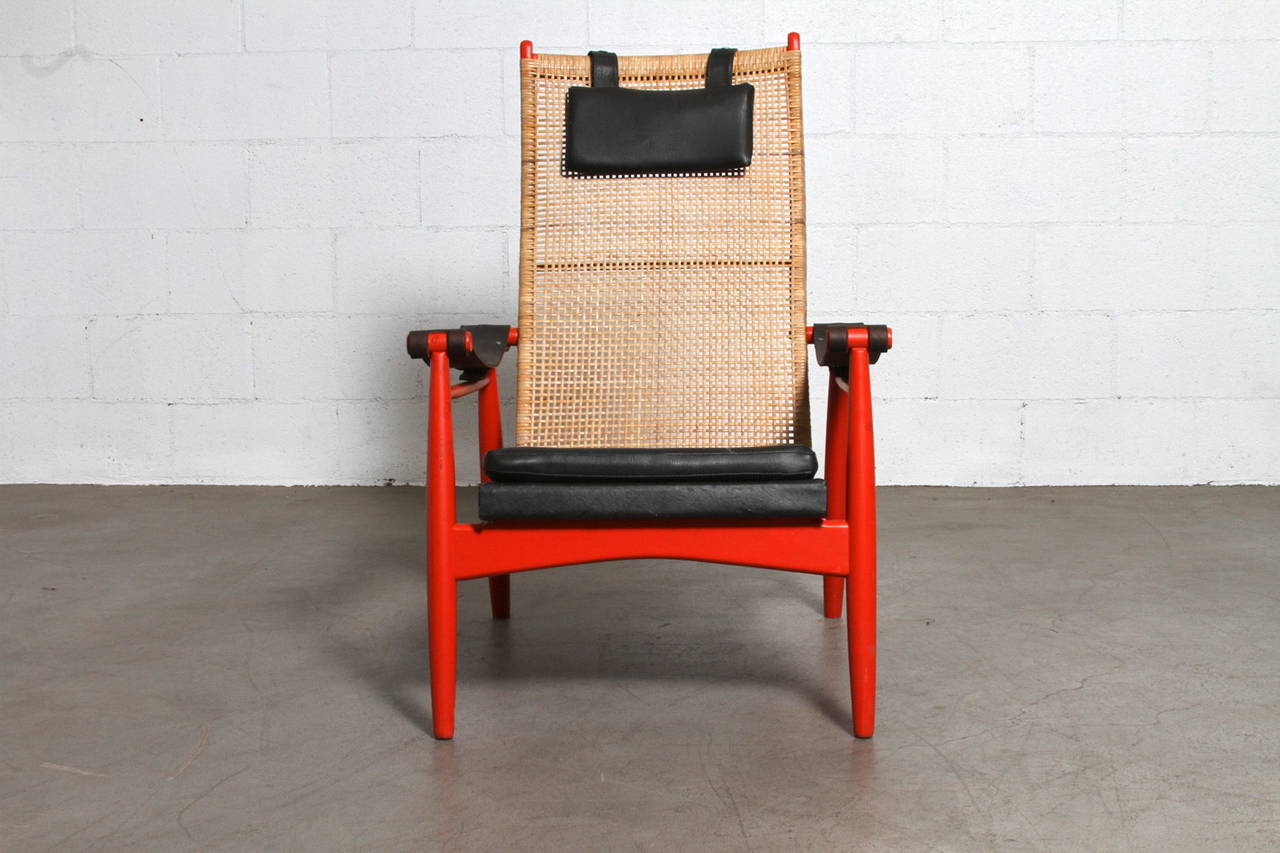 Lounge Chair designed by P.J. Muntendam for Gebr. Jonkers in 1950's. Beautifully Woven Rattan Back and Painted Red Wood Frame with Skai Upholstered Seat and Headrest Pillow. Worn Black Leather Armrests. Original Condition with Slight Wear to Rattan.