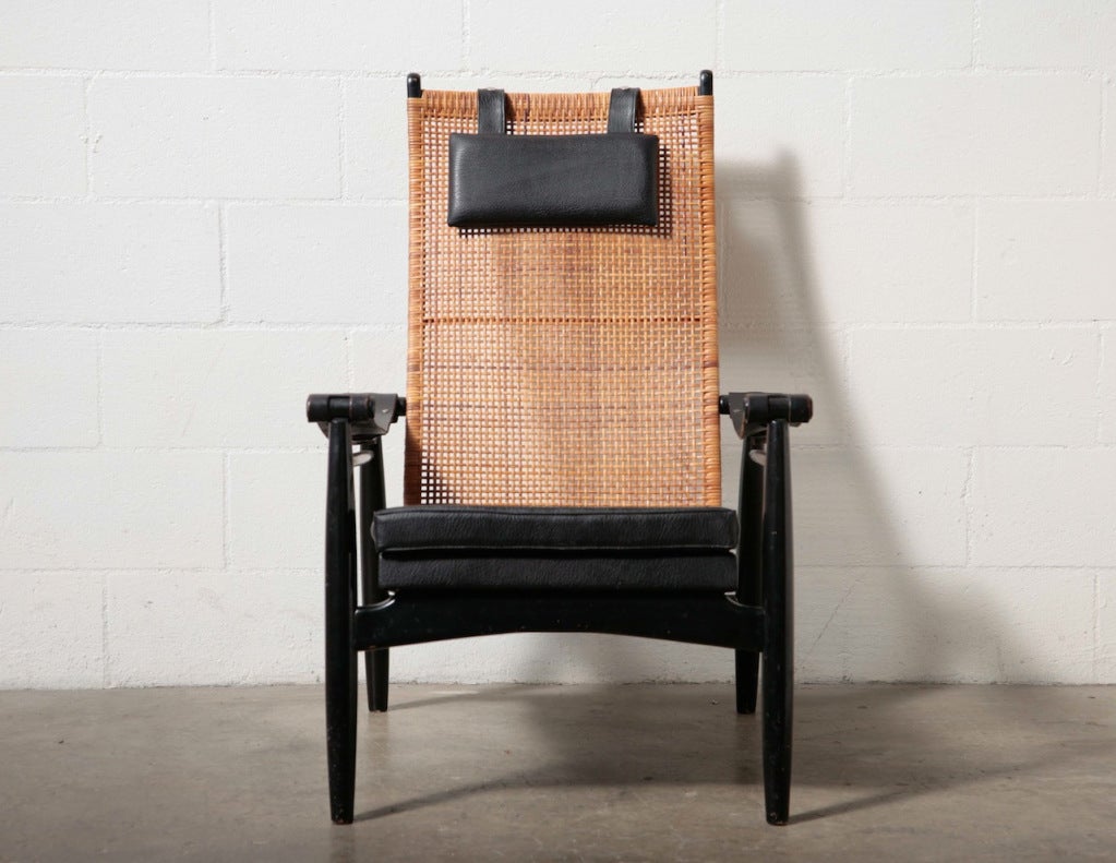 Lounge Chair designed by P.J. Muttendam for Gebr. Jonkers. Beautifully Woven Rattan Back with Ebonized Wood Frame, Leather Strap Arm Rests with Skai Upholstered Seat and Head Cushion.