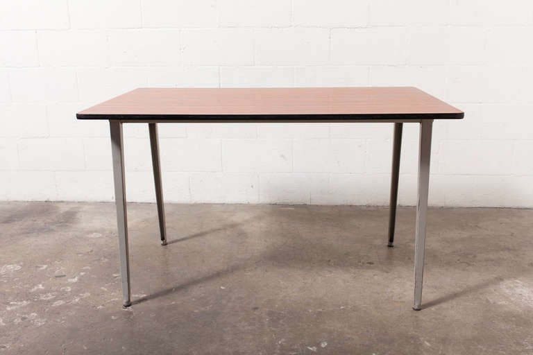 Sleek, mid century, Reform Table designed by Friso Kramer for Ahrend Circle in 1955.  Industrial enameled grey metal frame with faux teak wood formica top. Amsterdam's Stedelijk Museum has this in its permanent collection. In original condition with