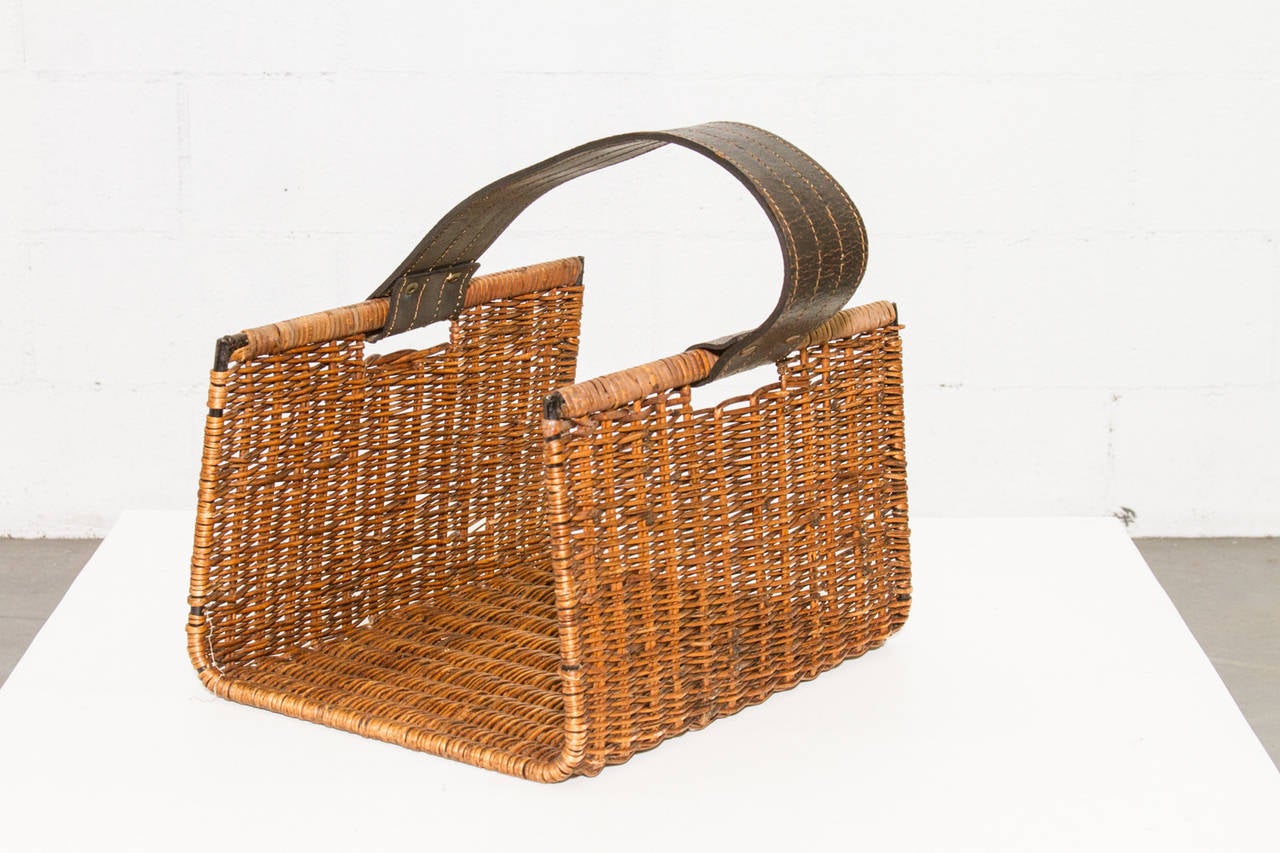 Handsome Catch all Woven Rattan Basket with Wide Leather Stitched Handle. Original Condition with some Wear to Rattan Consistent with Age and Use. Strap is 3.375