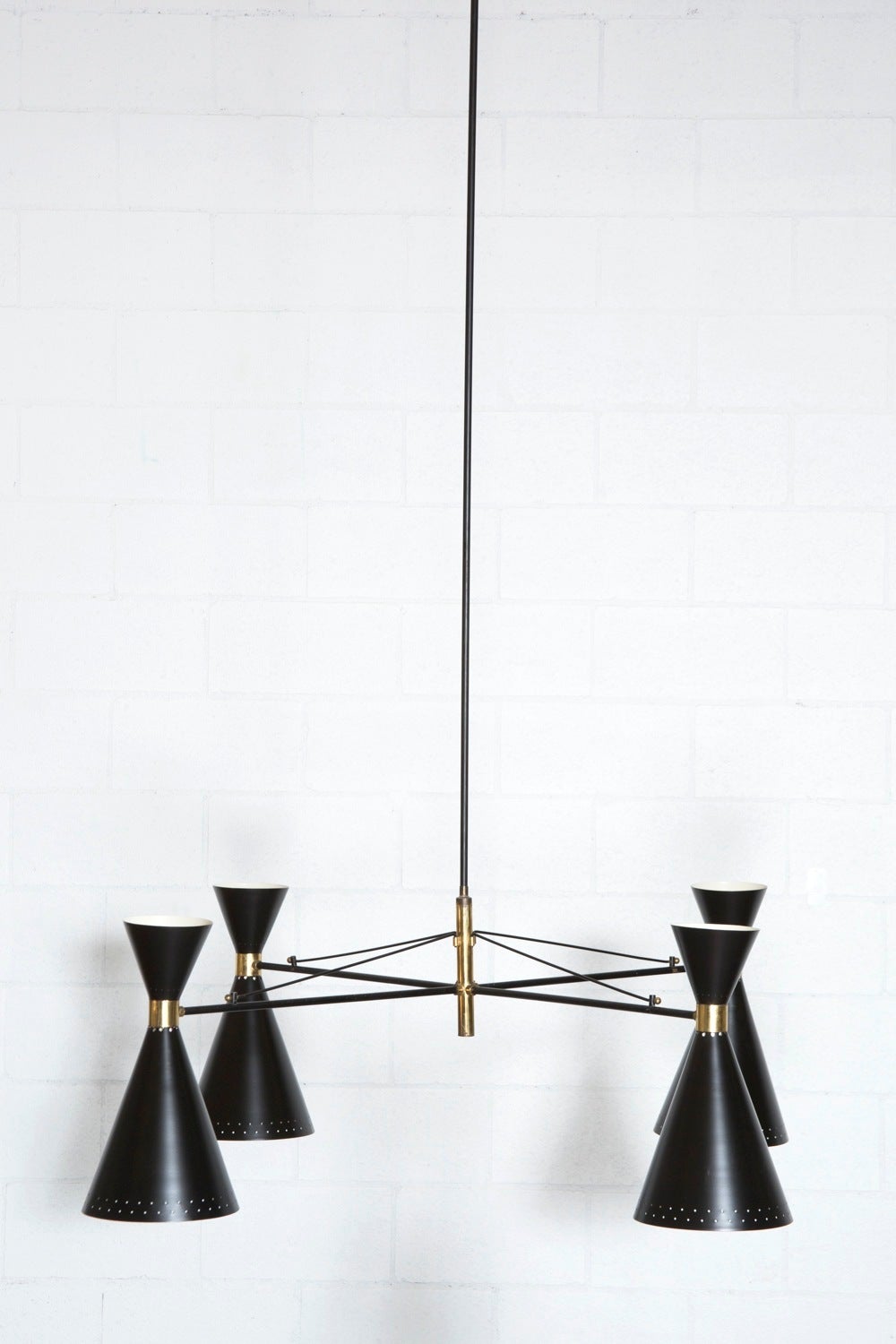 Massive and impressive Stilnovo style mid century chandelier with four spun aluminum, double cone, shades in enameled black with brass hardware and structure. Shade height is 17.75